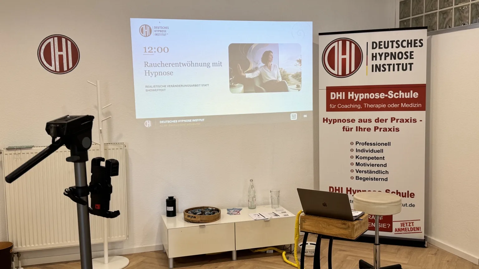 Gruppenbereich mit Beamerprojektion, DHI-Banner und Präsentationsaufbau